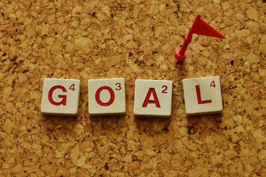 Scrabble tiles spelling 'GOAL' with a small red flag, symbolizing climate targets and updated Nationally Determined Contributions (NDCs) in 2025.