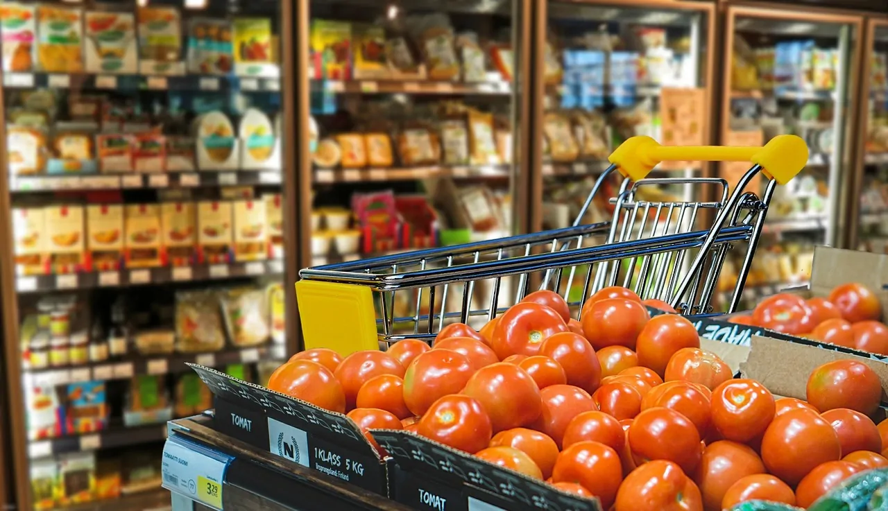 Shopping cart with tomatoes in a grocery store, representing everyday shopping