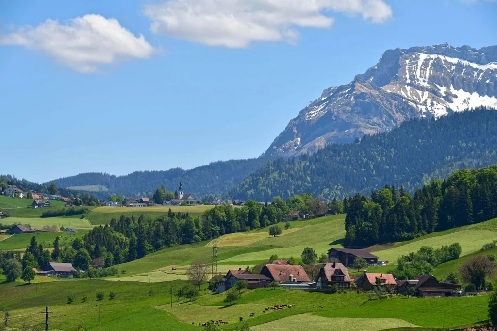 Scenic Swiss landscape with mountain and green valley representing sustainable living in UNESCO biosphere reserves