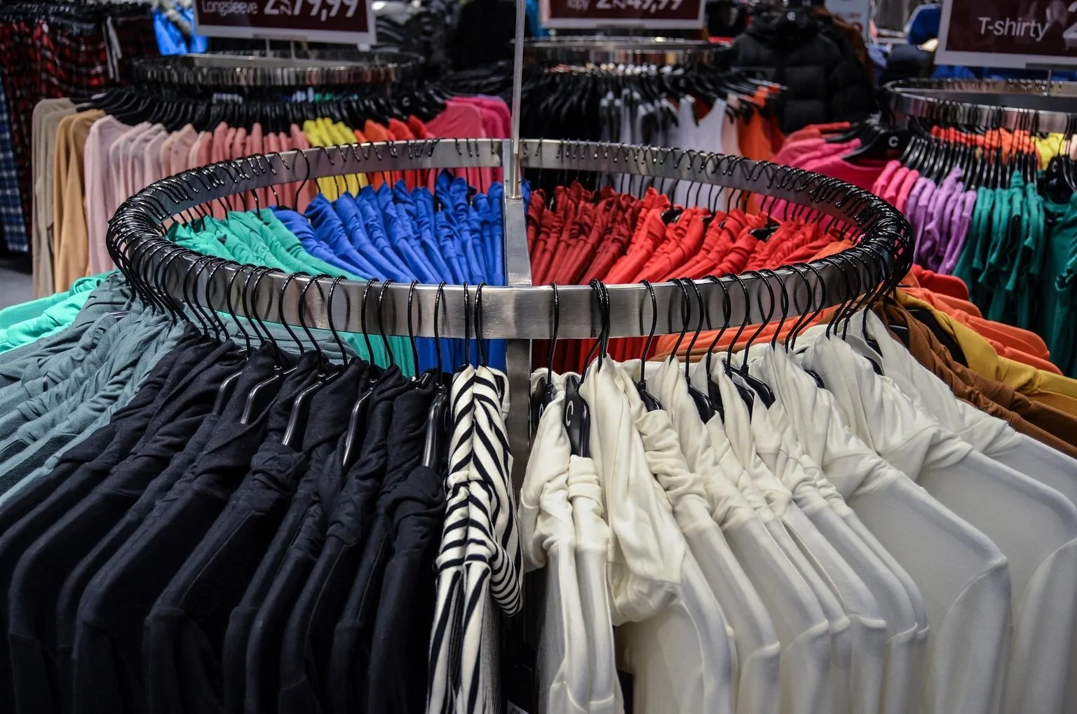 Colorful shirts on display in a fashion store representing fast fashion and sustainable clothing choices