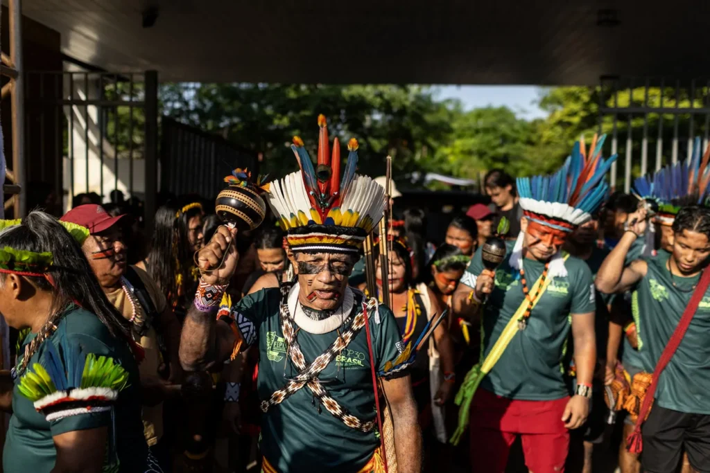 Indigenous leaders participating in a cultural march near COP30 in Belém, highlighting protest movements and public pressure at the UN climate summit